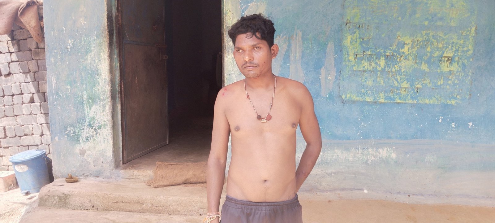 तेंदुए के हमले में घायल युवक घर के सामने खड़ा हुआ है।