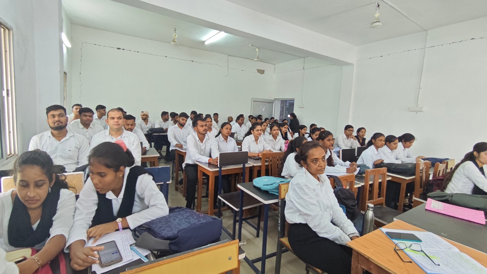 सेमिनार कक्ष में बैठे छात्र-छात्राएं और प्राध्यापक।