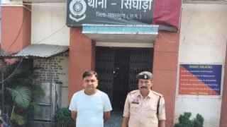 सिंघोड़ा थाना महासमुंद के सामने एक व्यक्ति और पुलिस अधिकारी खड़े हुए हैं।