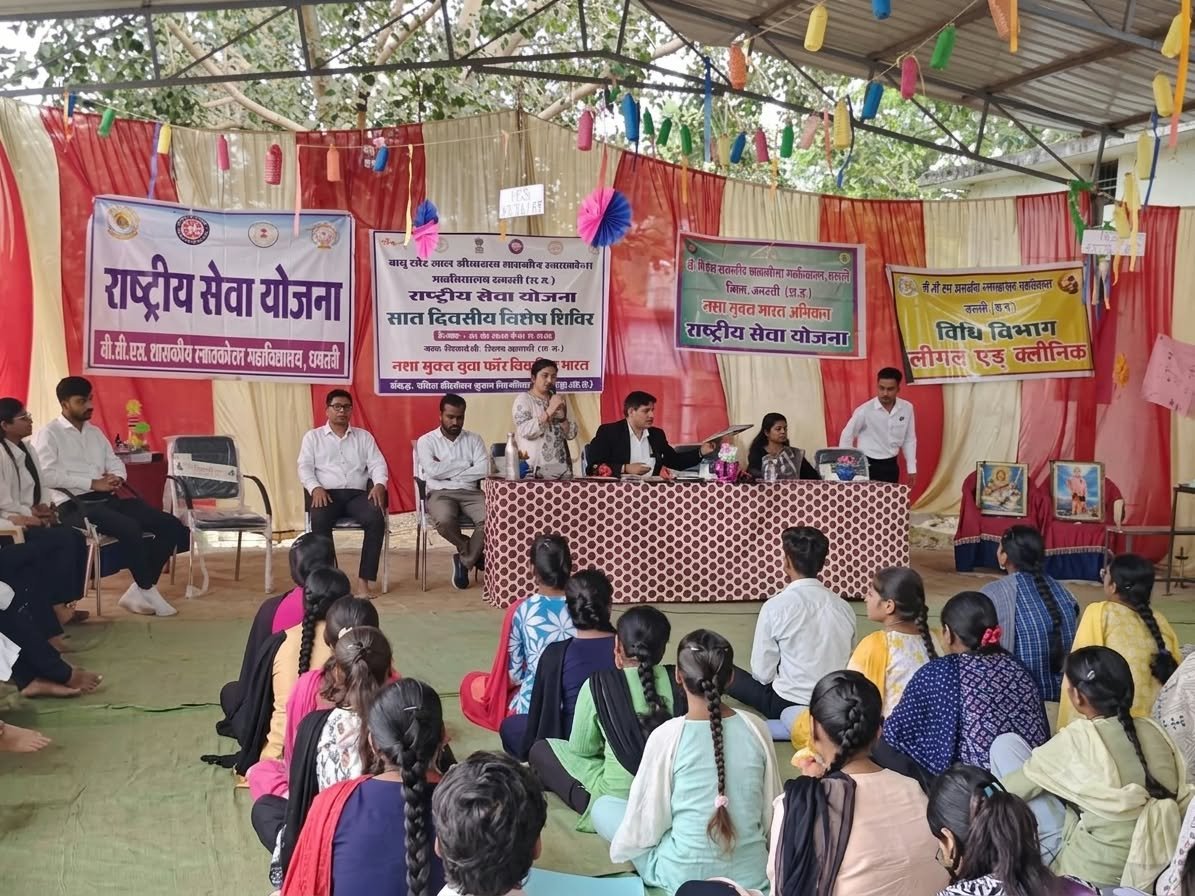 एनएसएस शिविर में मंच पर बैठे वक्ता और सामने बैठे स्वयंसेवक व ग्रामीण।