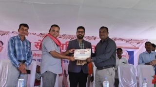 कोसरंगी में आयोजित सेवा सेतु शिविर के दौरान मंच पर प्रमाण पत्र लेते हुए व्यक्ति।
